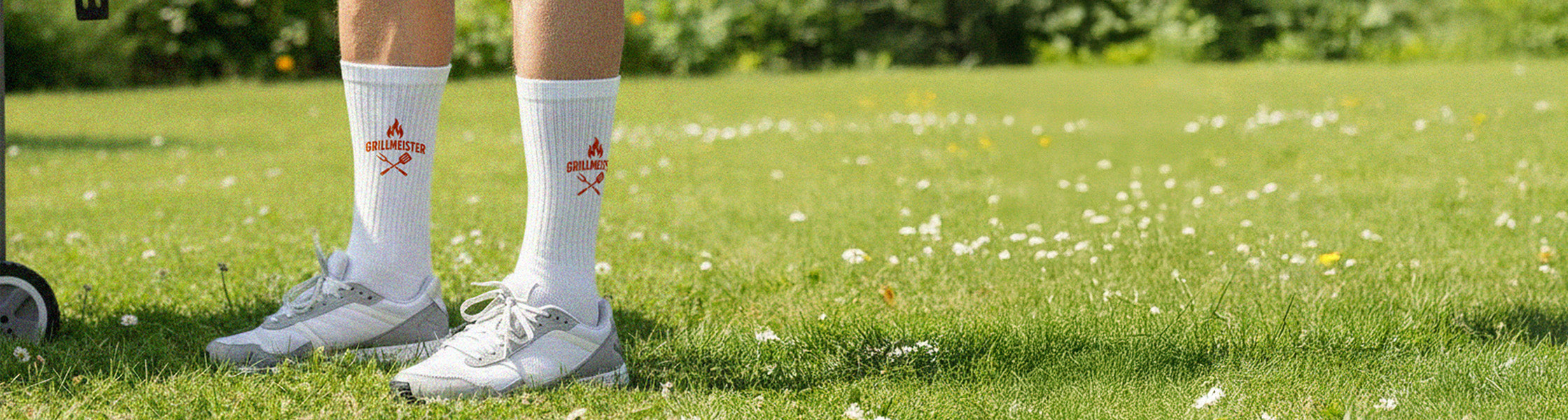 Person mit individuell bedruckten Tennissocken steht im Gras – Symbol für Qualität, Alltagstauglichkeit und Persönlichkeit von Sockenprinz.
