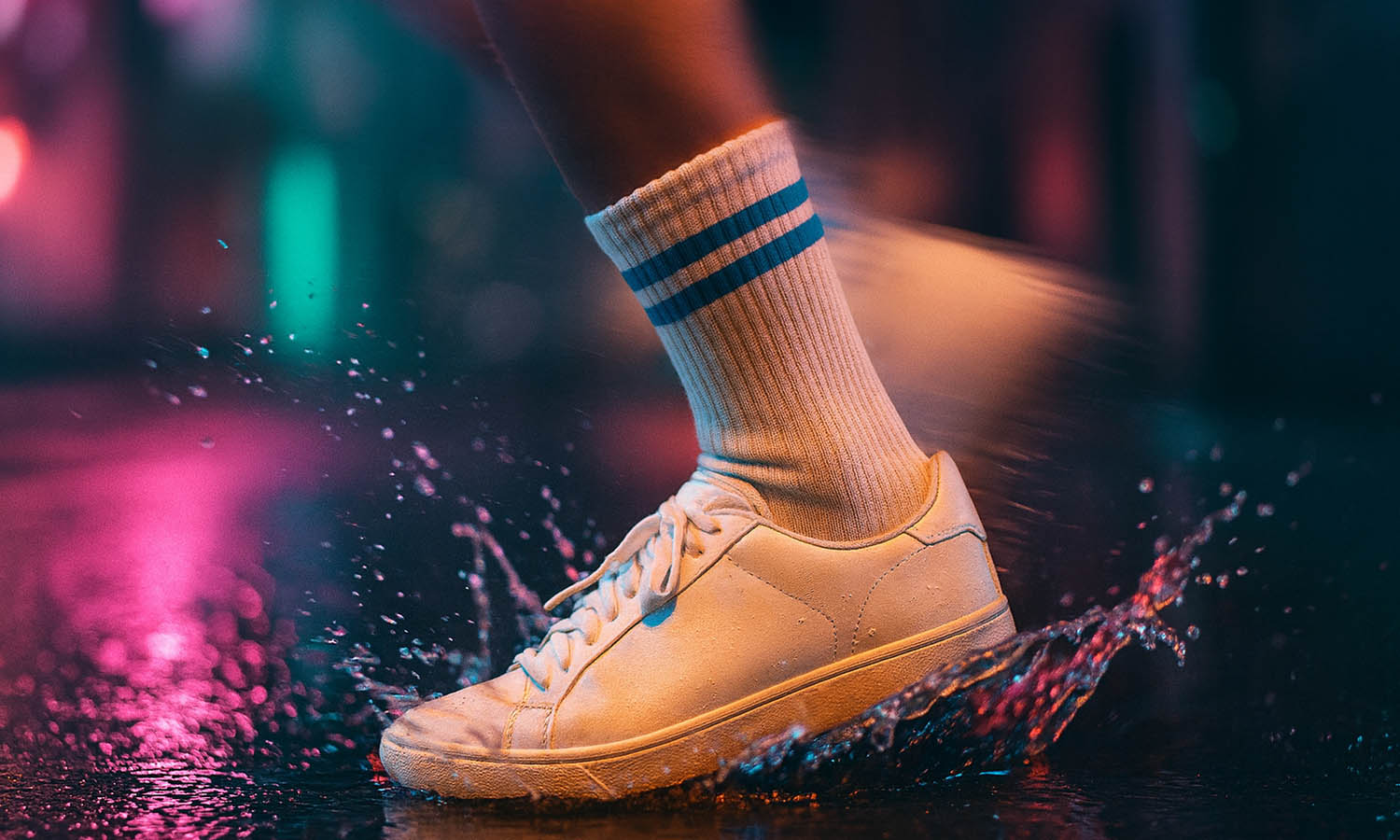 Sportliche Person mit weißen Tennissocken auf nassem Boden – steht für Stil, Qualität und Leidenschaft bei Sockenprinz.